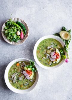 蓝色桌子上的三碗pozole verde汤。